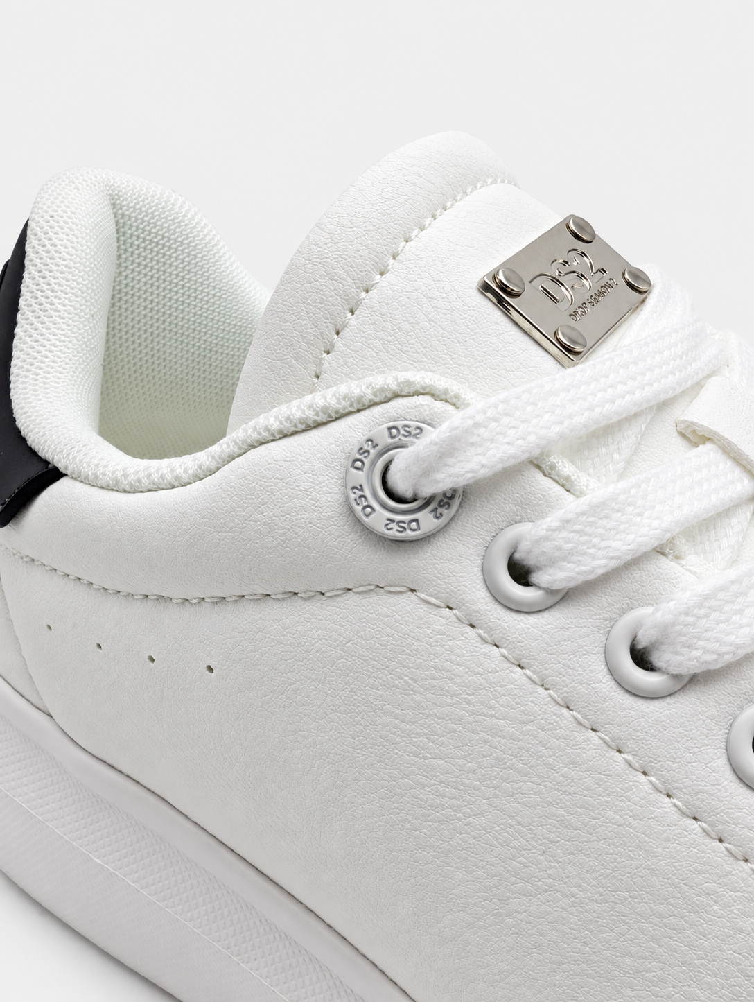 Dettaglio degli occhielli e dei lacci bianchi della sneaker DS2 Essential Oversize